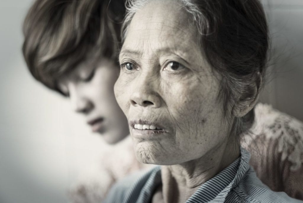 Woman with late-stage ovarian cancer, supported by her daughter, Hanoi Oncology Hospital, Viet Nam, 2016.